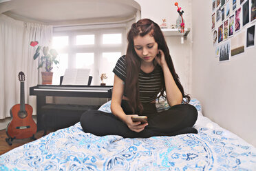 Teenager social networking on bed - CUF49163