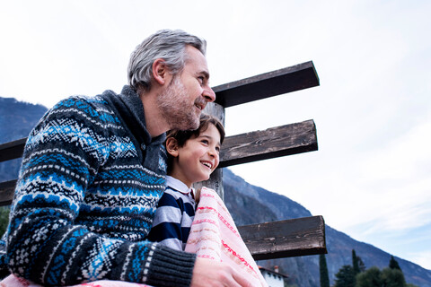 Junge und Vater mit Decke auf Seebrücke, Comer See, Onno, Lombardei, Italien, lizenzfreies Stockfoto