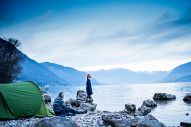 Father and son camping by lakeside, Onno, Lombardy, Italy - CUF49234