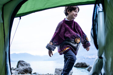 Junge spielt außerhalb des Zeltes am Seeufer, Comer See, Onno, Lombardei, Italien - CUF49256