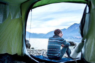Man camping on lakeside, view from inside tent, Onno, Lombardy, Italy - CUF49258