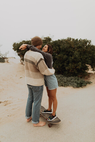Romantisches junges Skateboard-Paar von Angesicht zu Angesicht am Strand, Jalama, Kalifornien, USA, lizenzfreies Stockfoto