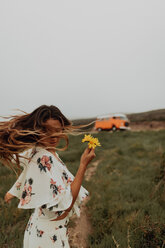 Junge Frau mit Wildblumen tanzt an der Küste, Jalama, Kalifornien, USA - ISF20559