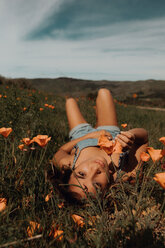 Young woman lying in field of wildflowers, portrait, Jalama, California, USA - ISF20567