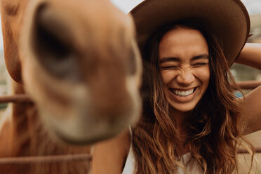 Junge Frau mit Filzhut lacht neben einem Pferd, Jalama, Kalifornien, USA - ISF20582