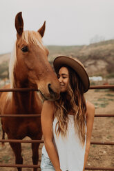 Junge Frau mit Filzhut Nase an Nase mit Pferd, Jalama, Kalifornien, USA - ISF20583