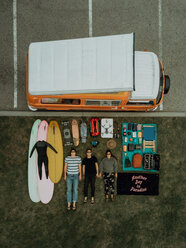 Drei junge Surfer mit Surfausrüstung und Wohnmobil auf dem Rücken liegend am Strandparkplatz, Porträt von oben, Ventura, Kalifornien, USA - ISF20591