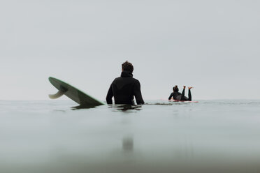 Junges Surferpaar auf Surfbrettern in ruhiger, nebliger See, Ventura, Kalifornien, USA - ISF20593