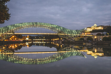 Georgien, Tiflis, Brücke des Friedens über den Fluss Kura bei Nacht mit dem Parlament im Hintergrund - KEBF01100