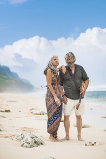 Senior hippie couple with guitar standing on the beach - SBOF01702