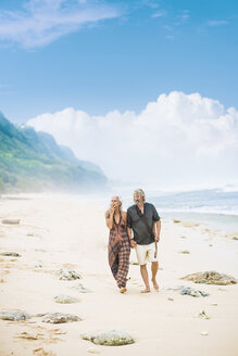 Älteres Hippie-Paar mit Gitarre schlendert Hand in Hand am Strand - SBOF01704