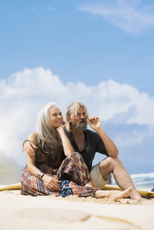 Portrait of senior hippie couple relaxing on the beach - SBOF01710