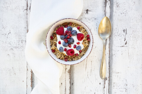 Bowl of muesli with Greek yogurt, popped quinoa, raspberries, blueberries and pomegranate seed stock photo