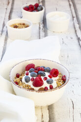 Bowl of muesli with Greek yogurt, popped quinoa, raspberries, blueberries and pomegranate seed - LVF07768