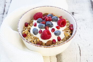 Bowl of muesli with Greek yogurt, popped quinoa, raspberries, blueberries and pomegranate seed - LVF07769