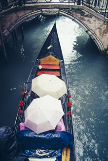 Italien, Venedig, Touristen in einer Gondel, die wegen des starken Regens unter Regenschirmen Schutz suchen - PPXF00168