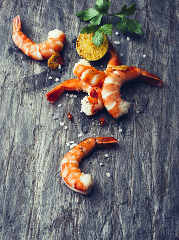 Gebratene Garnelen mit Chilipfeffer, Limette und Meersalz auf Schiefer, lizenzfreies Stockfoto