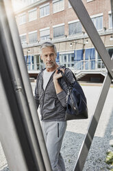 Porträt eines reifen Mannes mit Sporttasche auf dem Weg zum Fitnessstudio - RORF01711