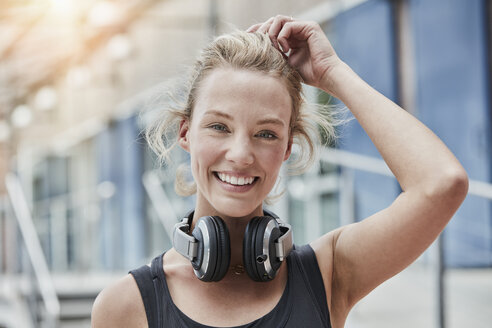 Portrait of smiling young woman with headphones - RORF01718