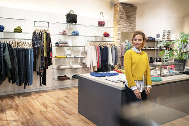 Young woman working in fashion store, using digital tablet - PESF01372