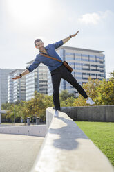 Portrait of man balancing on wall - GIOF05720