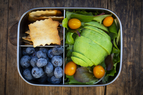 Lunchpaket mit Blattsalat, Avocado, Blaubeeren, Tomaten und Crackern, lizenzfreies Stockfoto
