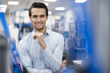 Portrait of smiling businessman in a factory - DIGF05655