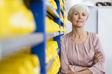 Portrait of confident senior woman in storehouse of a factory - DIGF05669