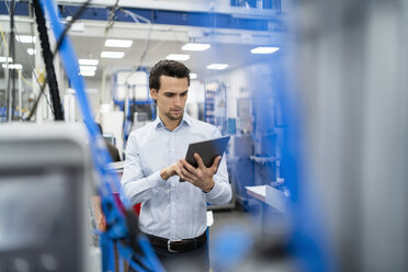 Businessman using tablet in a factory - DIGF05718