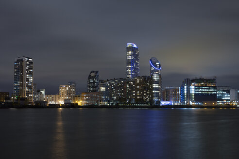 United Kingdom, England, London, Docklands, Isle of Dogs, modern apartment tower and office building at River Thames at night - WIF03821