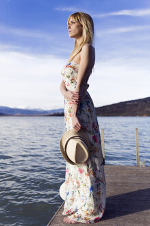Spanien, Cellers, nachdenkliche junge Frau im Sommerkleid mit Blumenmuster auf dem Steg stehend - JSRF00116