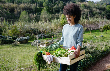 Frau trägt frisches Gemüse aus ihrem Garten - GEMF02712