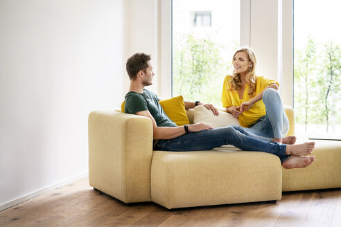 Ehepaar sitzt auf der Couch in ihrem neuen Haus und diskutiert - PESF01424