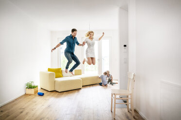 Glückliche Familie beim Einzug in ihr neues Haus, Eltern springen vor Freude - PESF01433