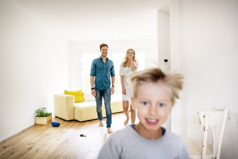 Glückliche Familie beim Einzug in ihr neues Haus, Eltern jagen ihren Sohn - PESF01435