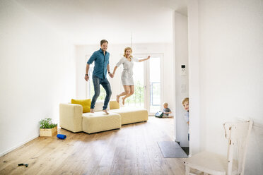 Glückliche Familie beim Einzug in ihr neues Haus, Eltern springen vor Freude - PESF01436