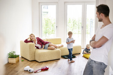 Glückliche Familie beim Einzug in ihr neues Haus, Eltern spielen mit ihren Kindern - PESF01438