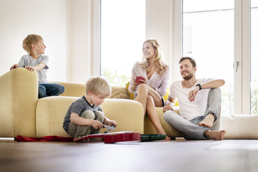 Glückliche Familie beim Einzug in ihr neues Haus, Eltern spielen mit ihren Kindern - PESF01442