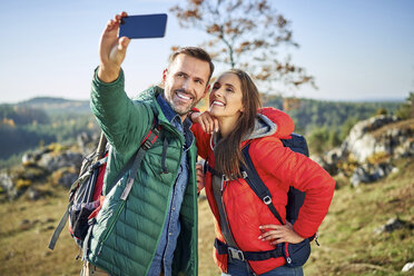 Happy couple on a hiking trip in the mountains taking a selfie - BSZF00922