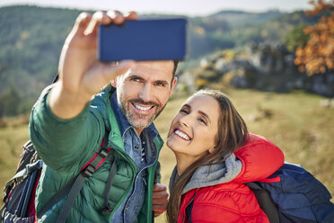 Happy couple on a hiking trip in the mountains taking a selfie - BSZF00923