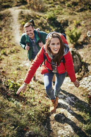 Glückliches Paar auf einem Wanderausflug in den Bergen, das den Pfad hinaufgeht, lizenzfreies Stockfoto