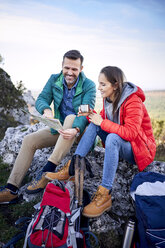 Glückliches Paar auf einer Wanderung in den Bergen, das eine Pause einlegt und auf die Karte schaut - BSZF00926