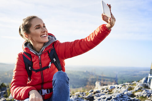 Glückliche Frau, die bei einer Wanderung in den Bergen ein Selfie macht - BSZF00944