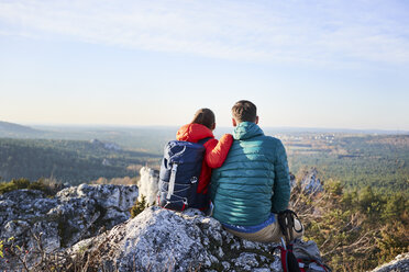 Couple sitting on rock and enjoying the view on a hiking trip in the mountains - BSZF00952