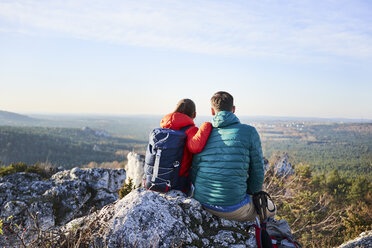 Ehepaar sitzt auf einem Felsen und genießt die Aussicht bei einer Wanderung in den Bergen - BSZF00952