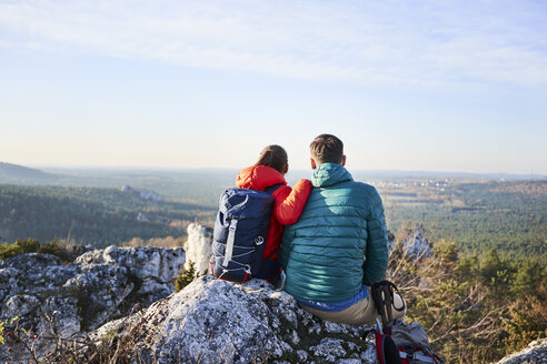 Ehepaar sitzt auf einem Felsen und genießt die Aussicht bei einer Wanderung in den Bergen - BSZF00952