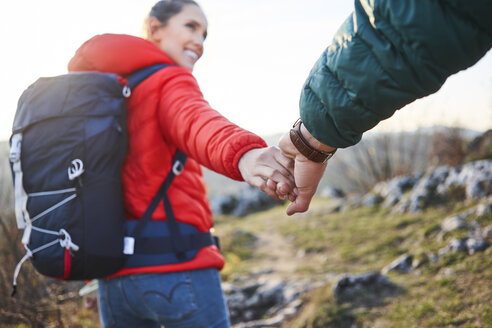 Nahaufnahme eines Paares, das sich bei einer Wanderung in den Bergen an den Händen hält - BSZF00953