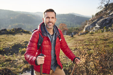 Porträt eines lächelnden Mannes bei einer Wanderung in den Bergen - BSZF00955