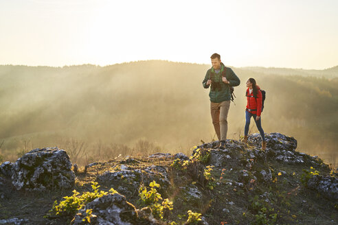 Couple on a hiking trip in the mountains walking on rocks - BSZF00973