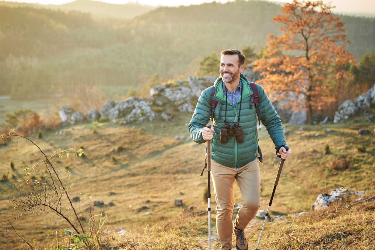 Happy man walking on trail on a hiking trip in the mountains stock